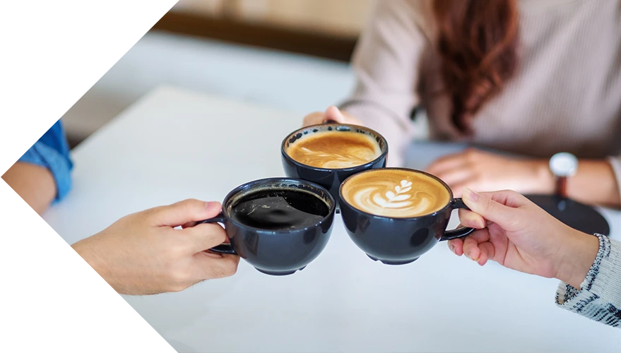 Three full coffee cups, 'cheers' together.